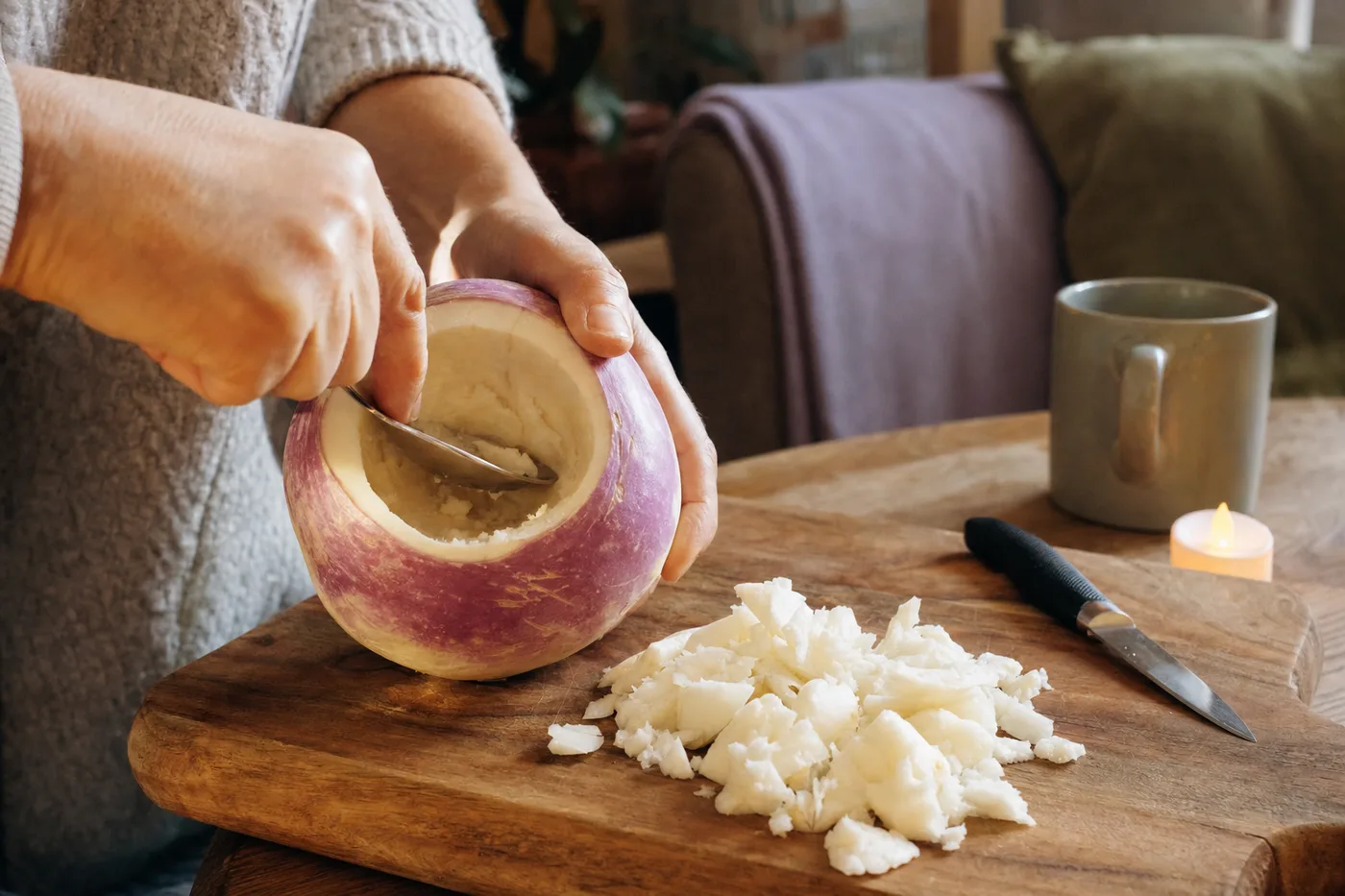 Hollowing out a raw turnip with a spoon to make a turnip lantern